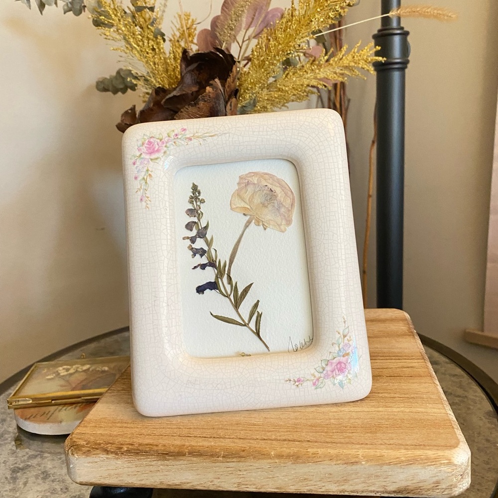 A vintage/antique frame with a handmade botanical artwork.